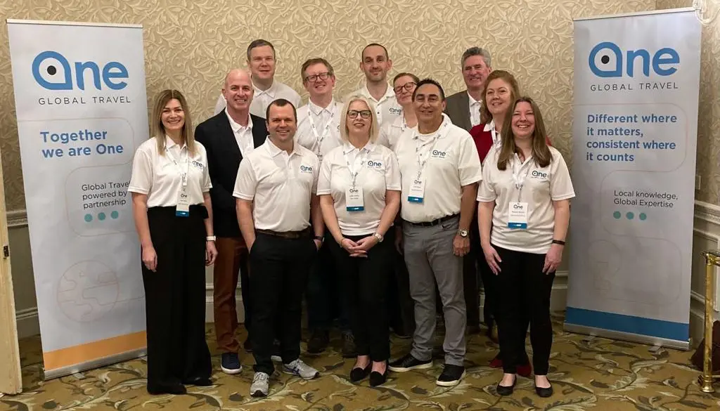 Group of twelve in white shirts at 2023 Global Partner Day event.