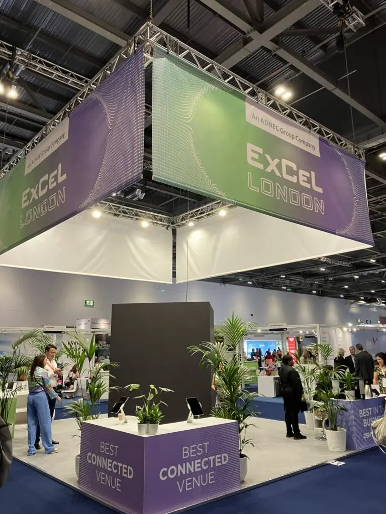ExCeL London at Business Travel Show with attendees, signage, and plants in venue.