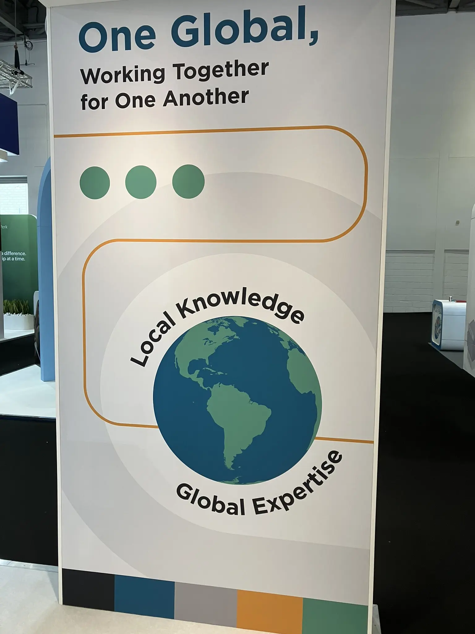 One Global, Working Together for One Another sign at Business Travel Show Europe.