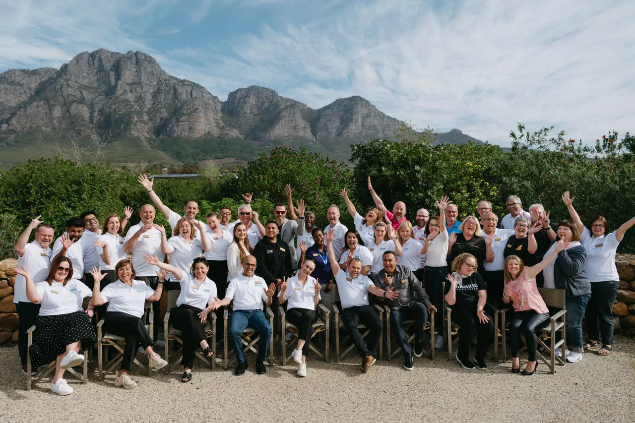Group at Global Community Partner Event outdoors with mountains in the background.