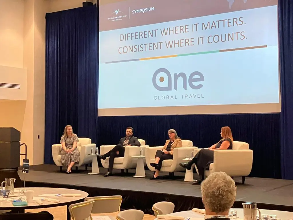Panel of four at World Travel Autumn Symposium 2024 with event logo in the background.