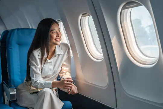 Woman in white outfit smiling, November airline update.