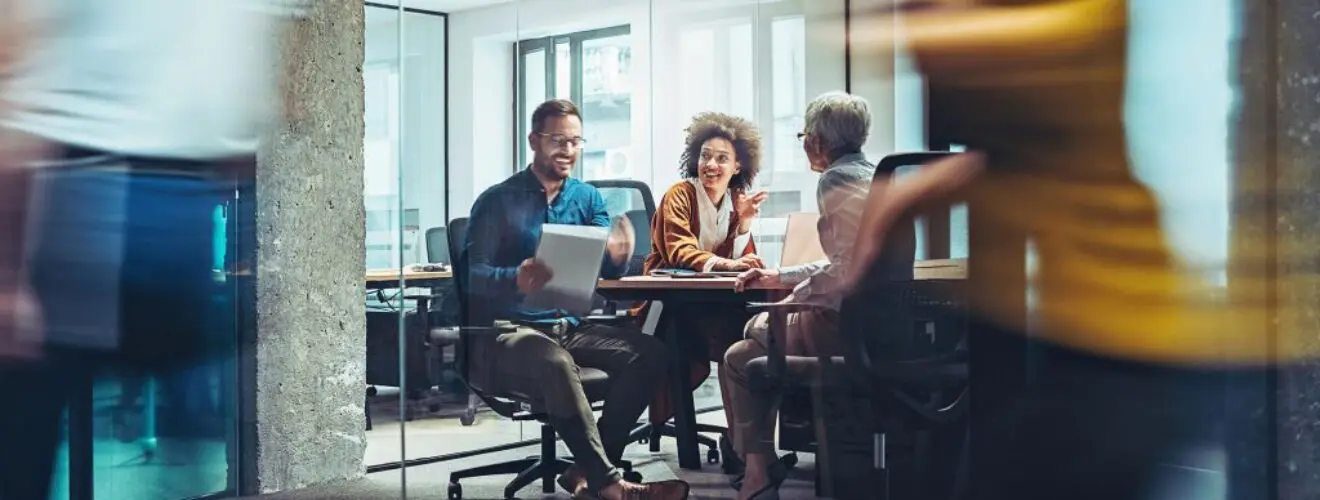 Corporate Travel Partners colleagues discussing strategies in a modern office.