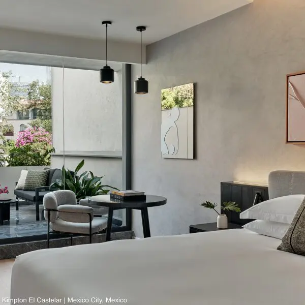 Modern IHG hotel room with balcony plants and seating, great for business travellers.
