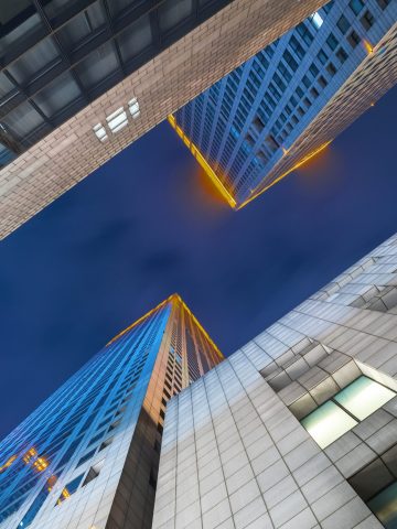 Tall modern skyscrapers viewed from below, inspired by travel and local expertise.