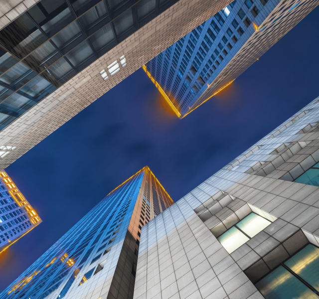 Skyscrapers from below with glowing edges, representing Business Travel Solutions.