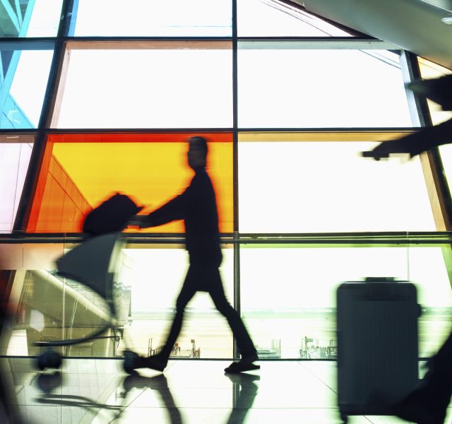 Passengers pushing luggage carts in airport terminal